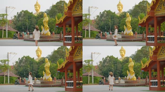一名女子在曼谷的金佛背景下走在寺庙里