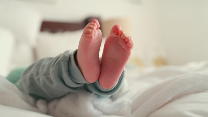 特写，婴儿的脚和鞋底在床上在家里的发展，踢和运动技能，健康和成长的移动。刚出生的婴儿，脚或在托儿所玩