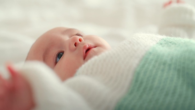 婴儿，可爱的新生儿躺在卧室的床上，在一个舒适、关心和爱的家里快乐。婴儿、发育和幼儿在快乐的托儿所中放