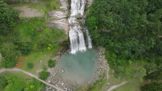 空中无人机看到的瀑布(cascata piumogna)被郁郁葱葱的绿树包围