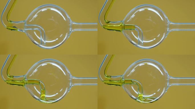 黄色的天然油在实验室的玻璃烧瓶中流动。