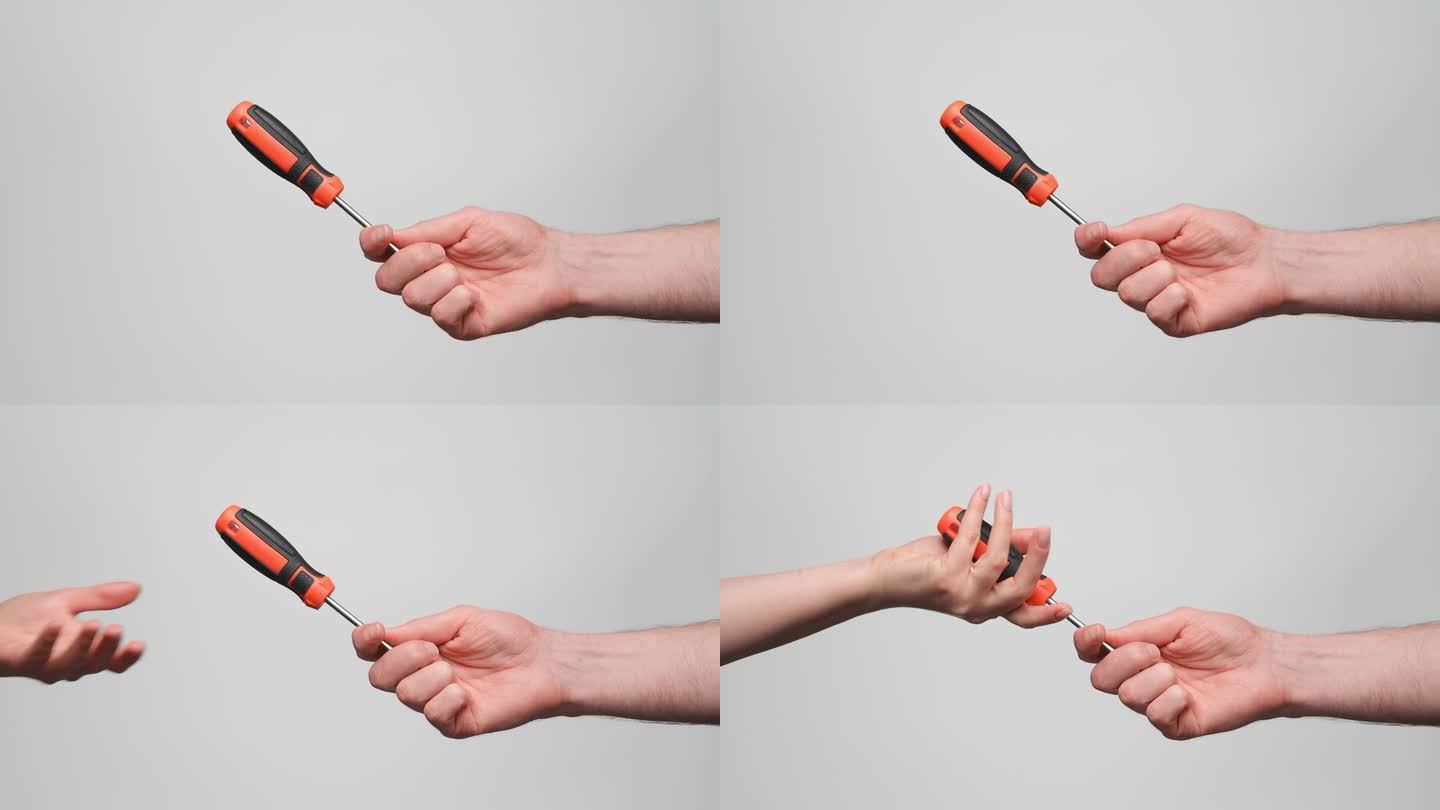 一个男人把黑橙相间的螺丝刀送给一个女人。特写，慢镜头，4k。