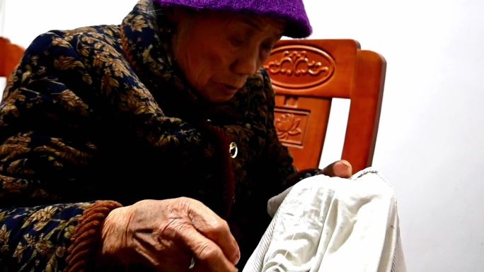 年迈的老奶奶缝衣服