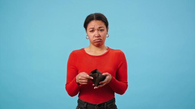 可怜的非裔美国妇女摇着空钱包找钱