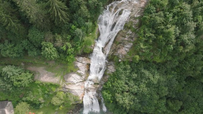 空中无人机看到的瀑布(cascata piumogna)被郁郁葱葱的绿树包围