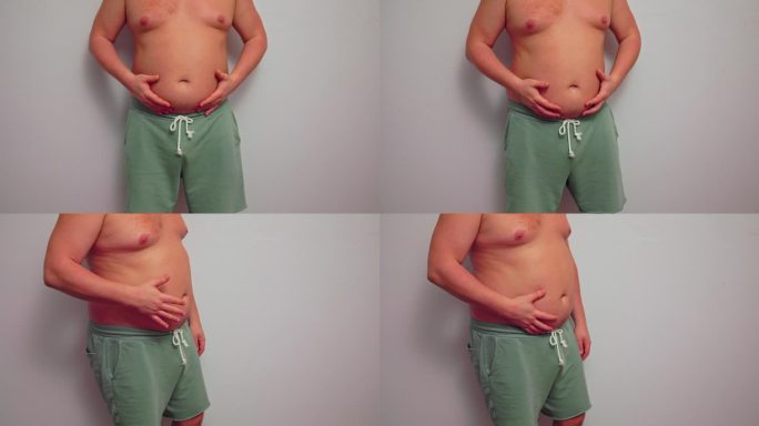 身材魁梧的男人炫耀他的大肚子。超重是一个健康问题，需要减肥和节食。