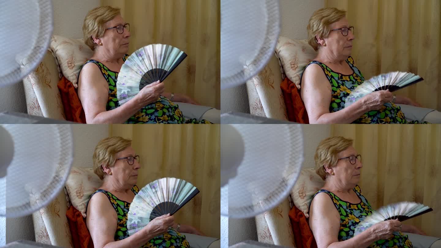 电风扇为一位年长的妇女降温，背景是手扇