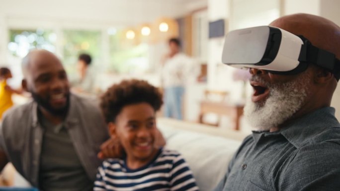 爷爷戴着VR头显，多代男性家庭一起坐在家里的沙发上
