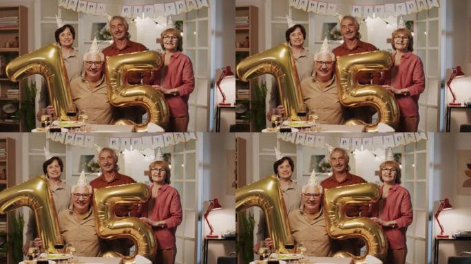 快乐的退休老人拿着75号形状的气球摆姿势拍照