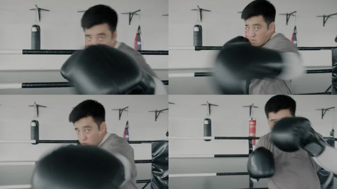 年轻的亚洲拳击手影子搏击，投掷拳头，看着摄像机在健身房的慢动作肖像