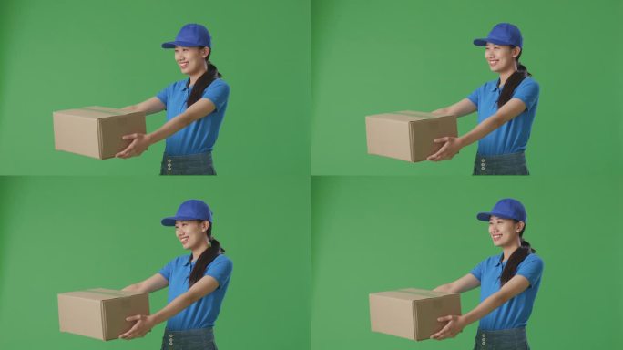 穿着蓝色制服的亚洲女快递员在工作室绿屏背景下微笑着给人送纸盒