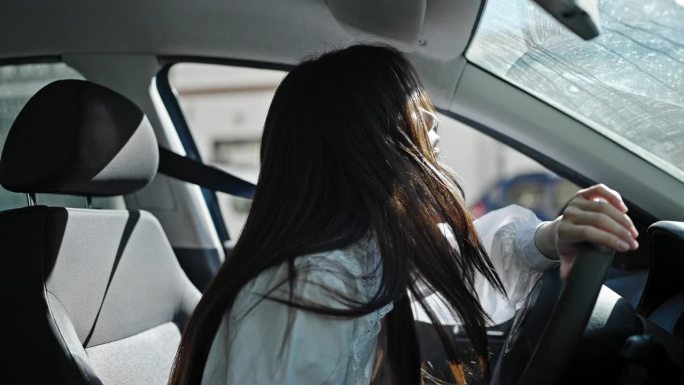 年轻的中国妇女在街上开车很紧张