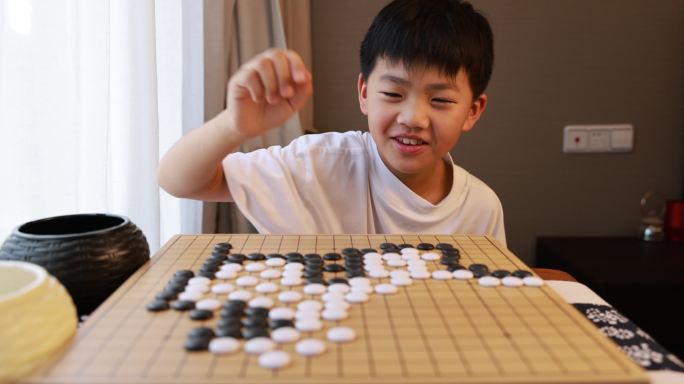 可爱的男孩在窗边下围棋