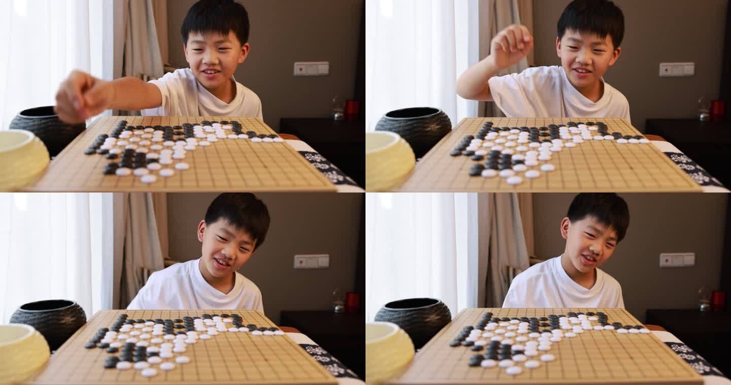 可爱的男孩在窗边下围棋