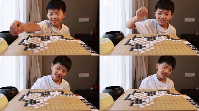 可爱的男孩在窗边下围棋