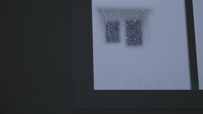 在黑暗的日子里，雨滴落在房子的窗户上，慢动作