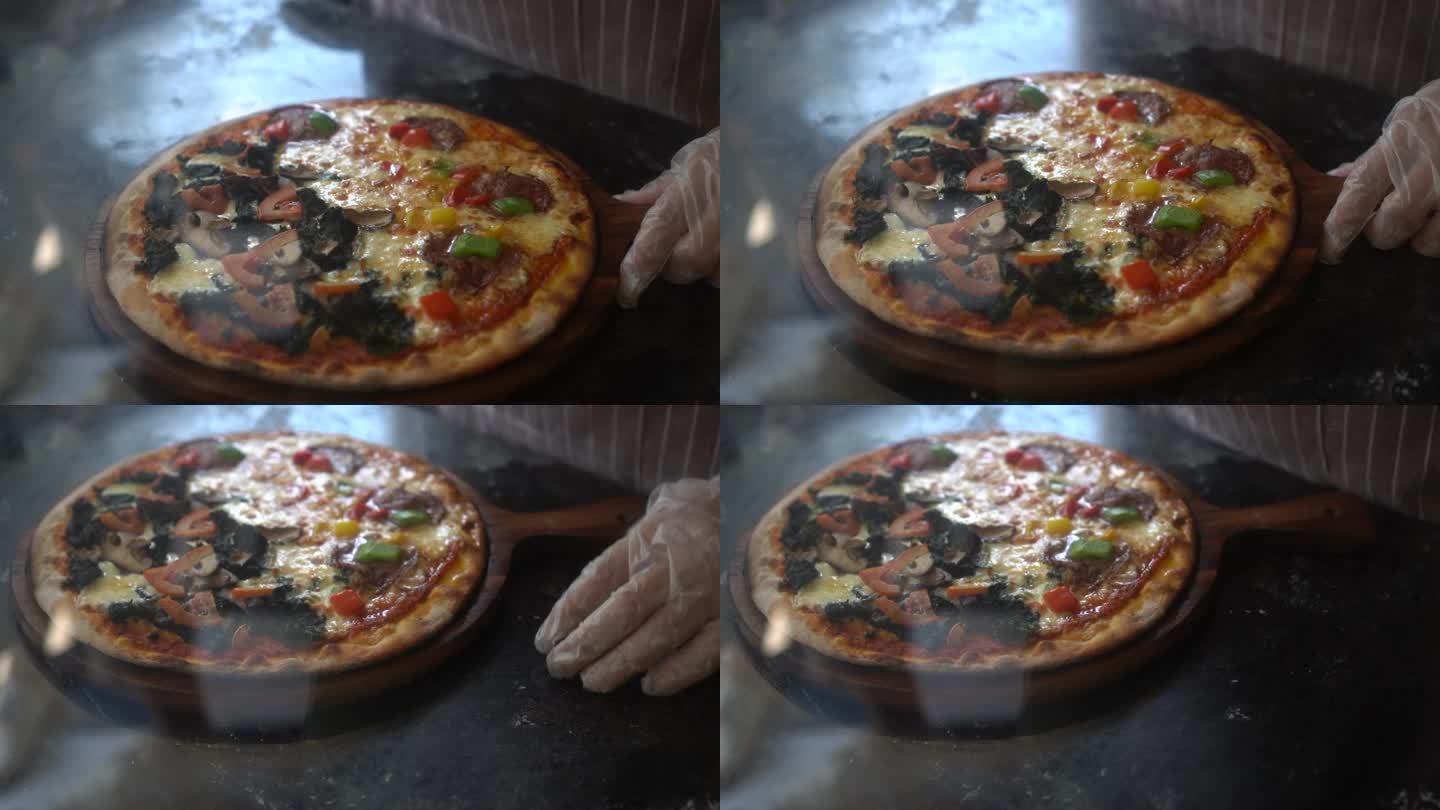 意大利厨师在披萨店准备用轮刀切两个披萨。