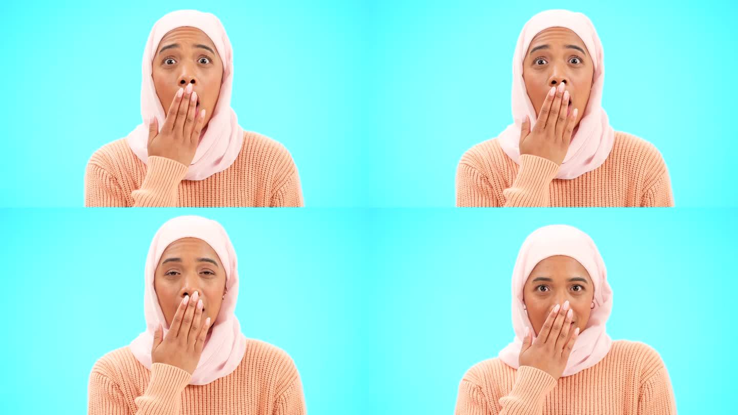 穆斯林妇女，用手捂着嘴拍模特、广告或促销。一名伊斯兰女性戴着头巾，在蓝色背景上用表情符号表达对销售、