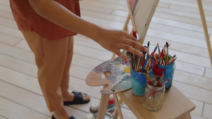 画笔和手的匿名艺术家拿起调色板