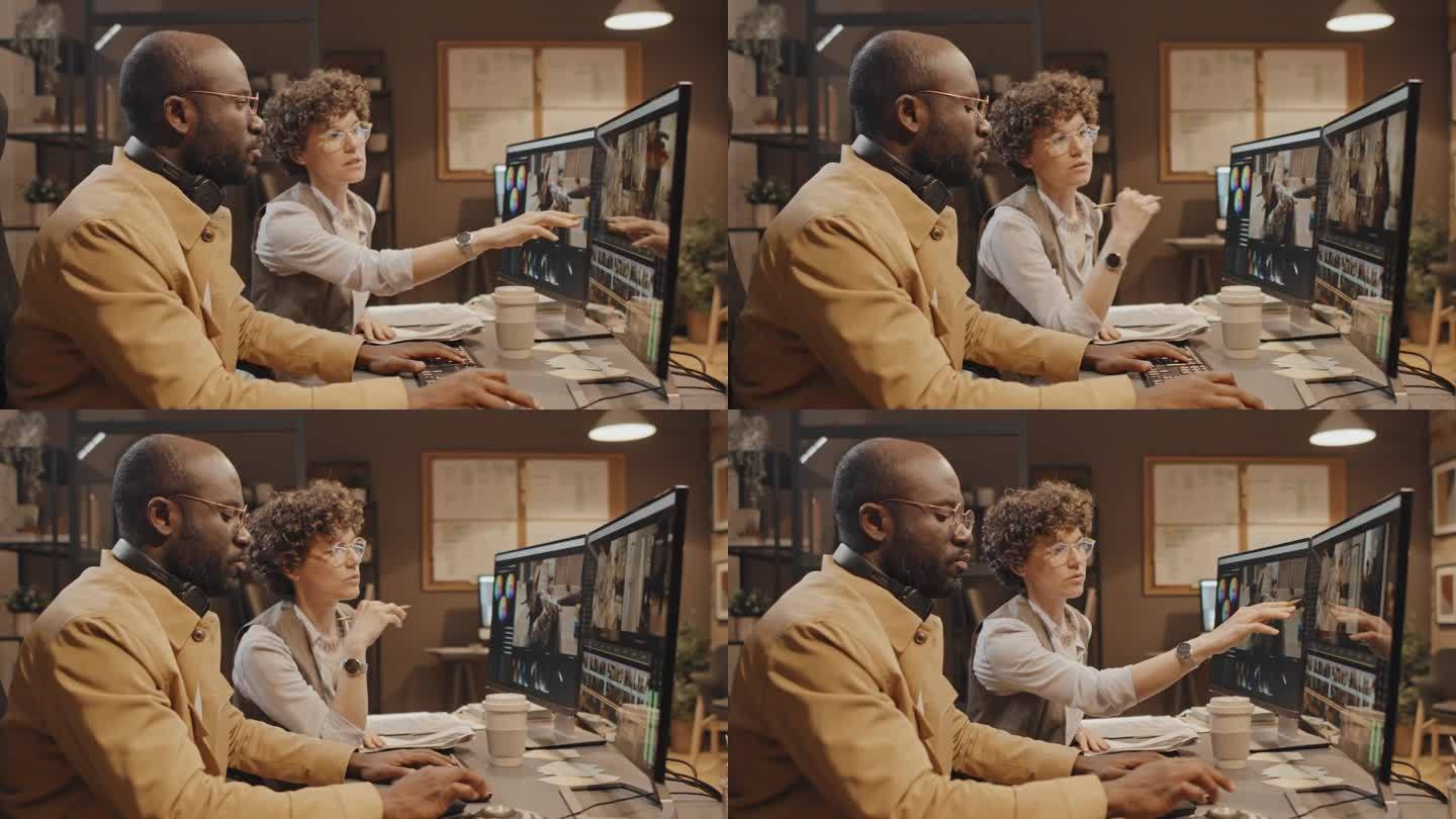 两个同事坐在电脑前讨论录像