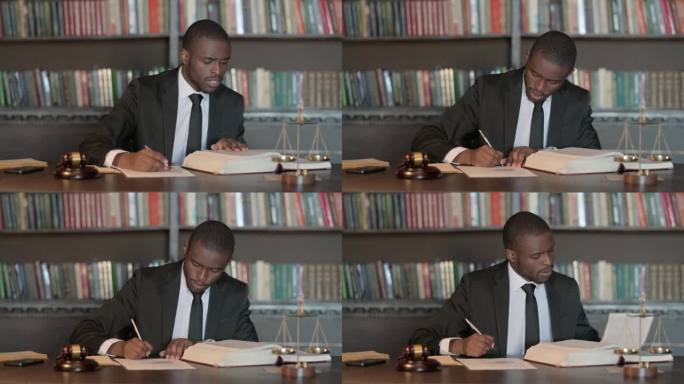 沉思的非洲男律师阅读法律书籍，准备出庭