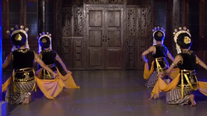 一群巴厘岛舞者在舞台上表演黄色披肩