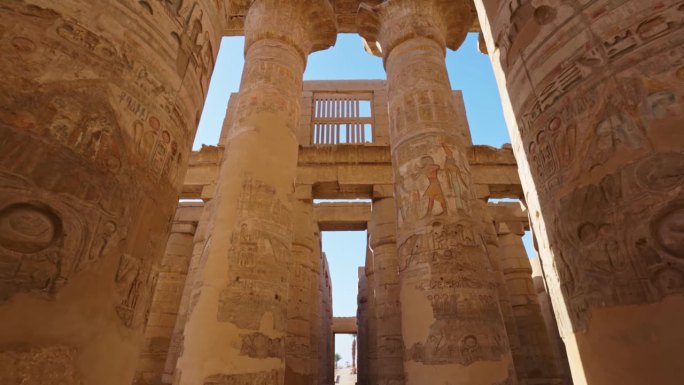 埃及卢克索的卡纳克神庙。摄像机在带有古埃及绘画的雄伟圆柱之间移动。万向节高质量拍摄