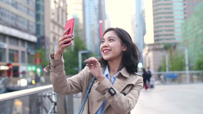 美丽女孩城市街头用手机拍照旅游快乐