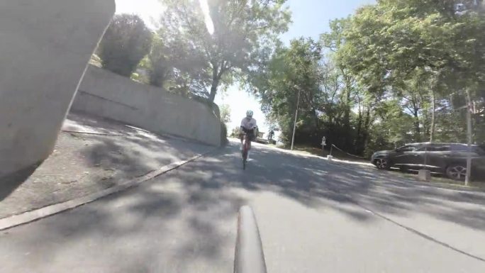 公路自行车骑手的低角度相机视图在自行车下行铺设山路