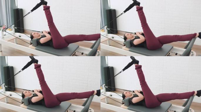 在普拉提健身机上锻炼的女性，健康的健身生活方式。