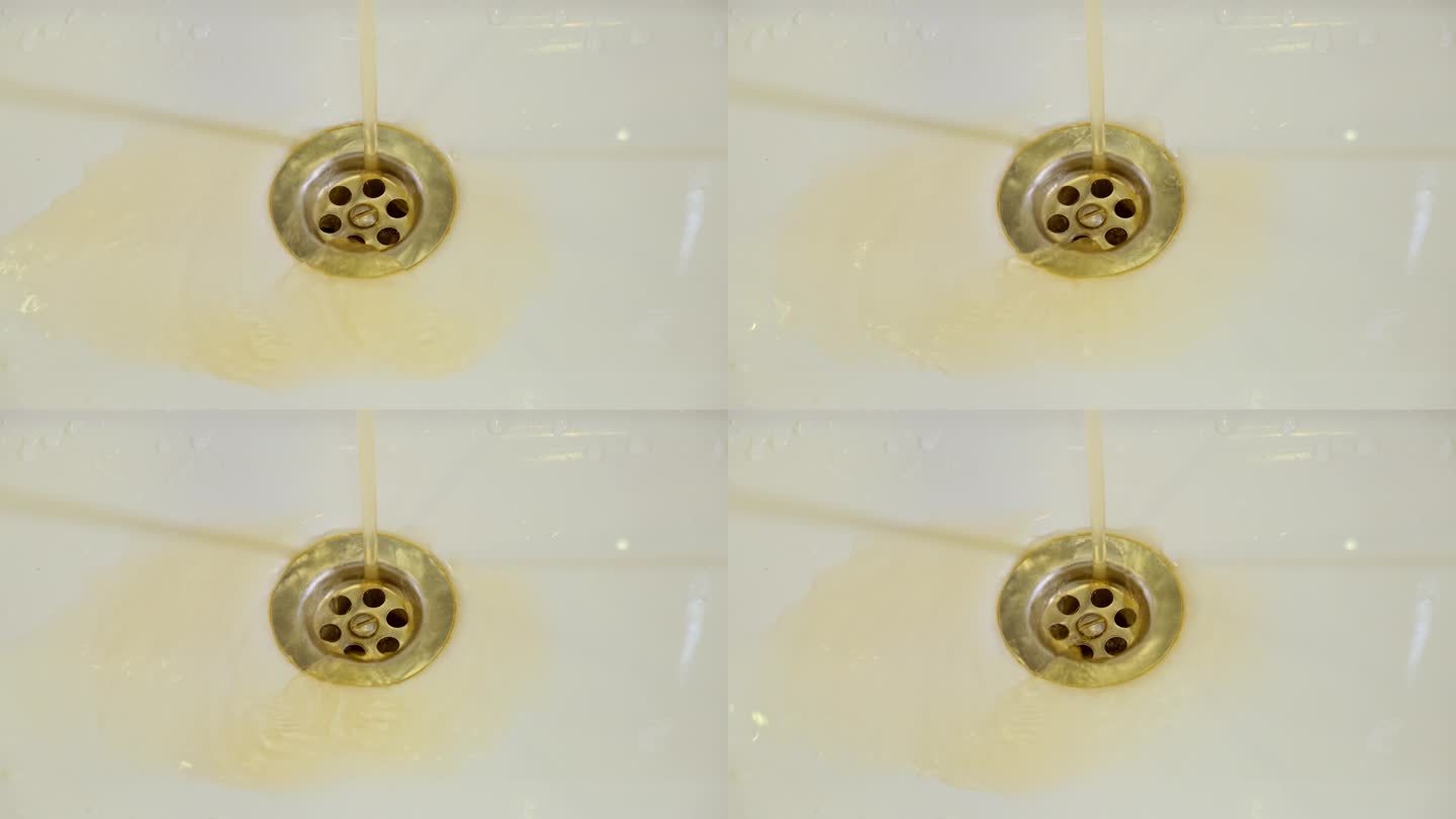 生锈的液体正从金属水槽的洞里滴出来，这显然表明管道有问题。