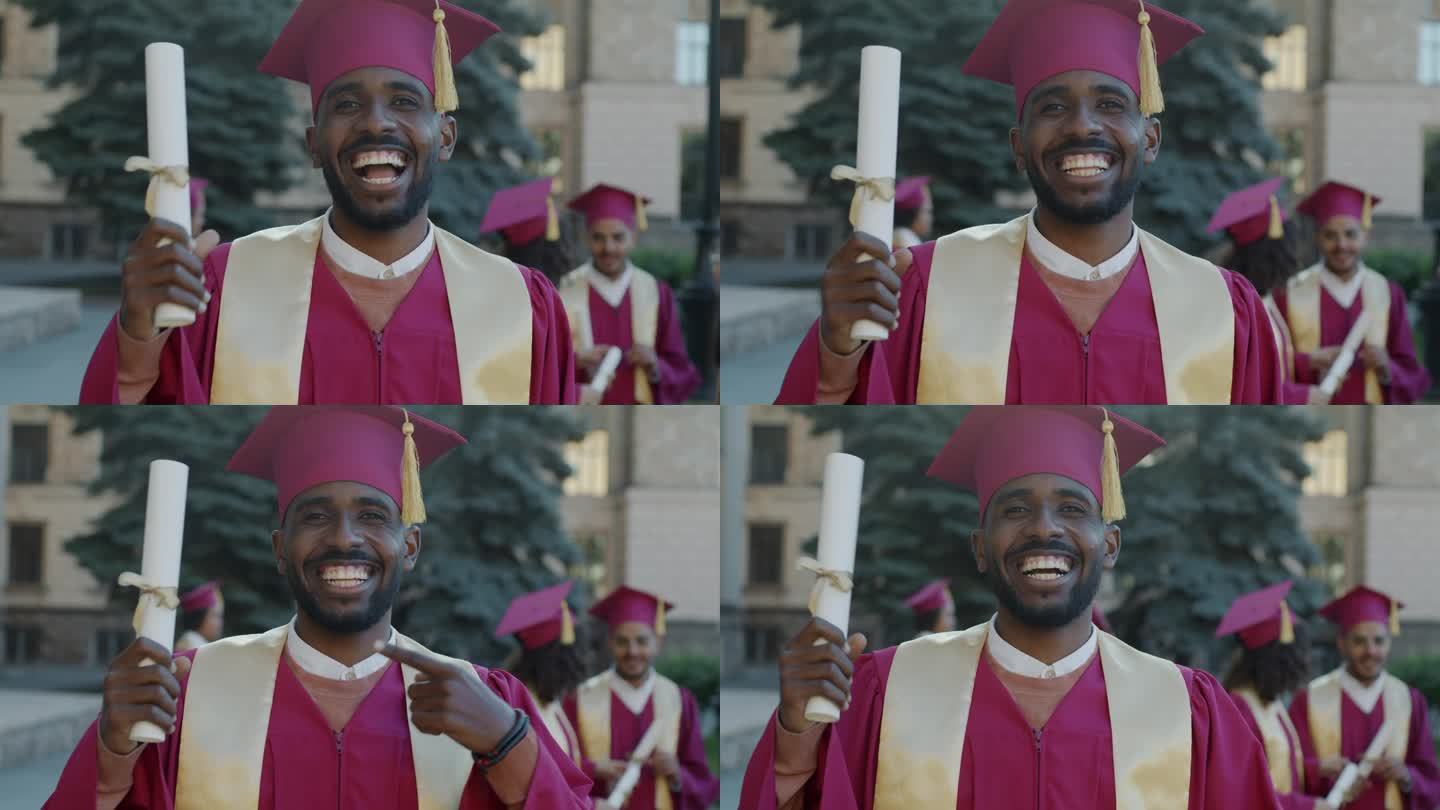 一个兴奋的非裔美国人戴着毕业帽站在校园里笑着挥舞着文凭的慢动作肖像