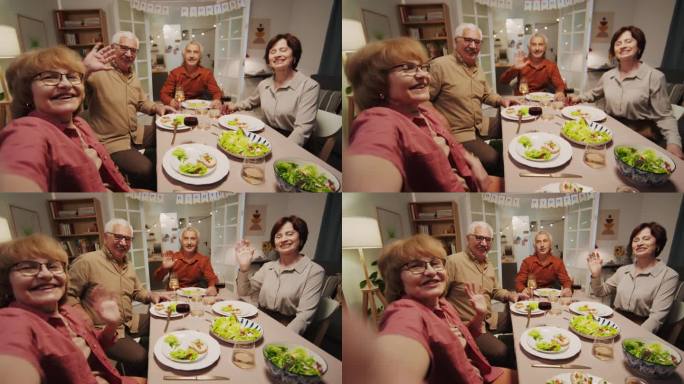 积极的老年人在餐桌上与朋友视频通话