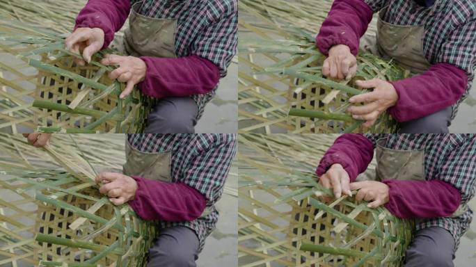乡村老人在院子里用竹条编竹篮