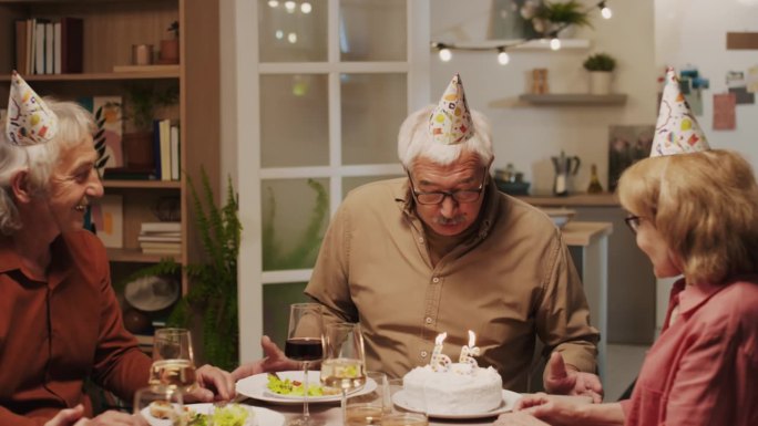 65岁生日老人吹灭蛋糕上的蜡烛