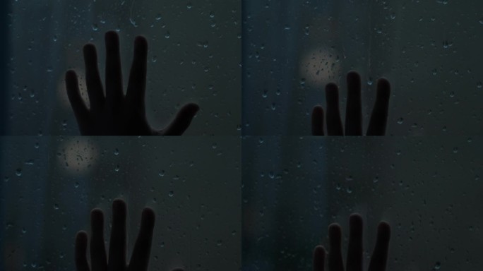 孩子的手滑到窗玻璃上，窗外下着大雨，电闪雷鸣。有选择性的重点。大雨，黄昏，忧郁的孩子在雨中