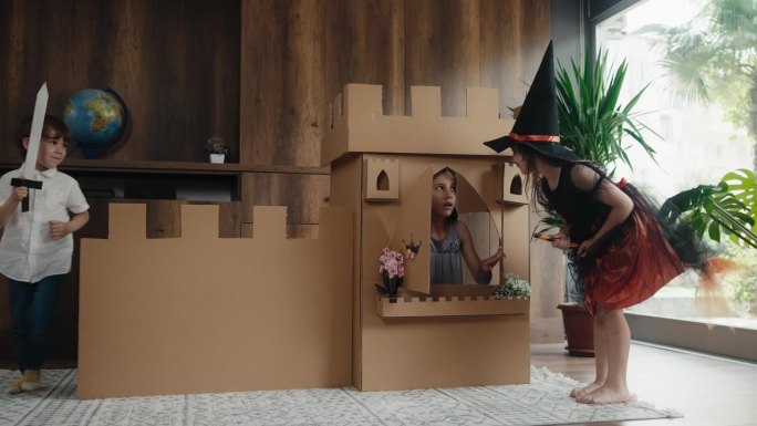 公主，王子和女巫在家里用纸板做的城堡玩角色扮演游戏