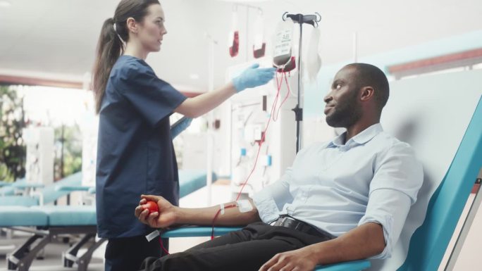 非洲商人在光明医院为有需要的人献血。女护士带着平板电脑进来检查供体的进展和健康状况。为癌症患者捐款。