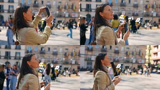 女游客用她的智能手机在城市广场中央拍摄建筑