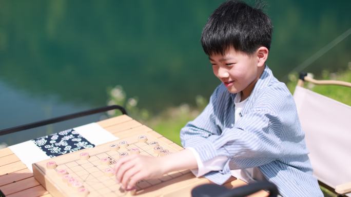 在湖边下棋的中国男孩慢镜