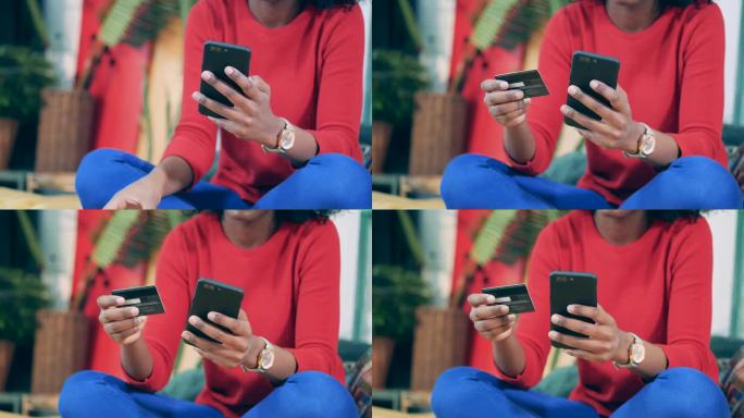 一名非洲妇女在网上购物时手持手机和卡片