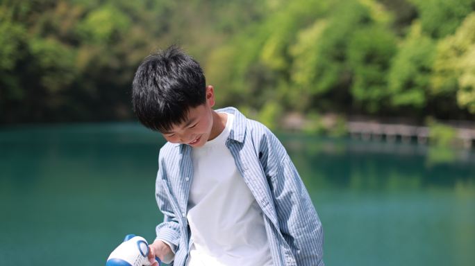 中国小男孩春日踏青，湖边玩泡泡机唯美升格