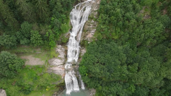 空中无人机看到的瀑布(cascata piumogna)被郁郁葱葱的绿树包围