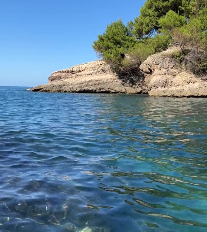 蓝色的大海和岩石在松木海岸在夏天，垂直视频。