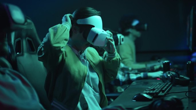 中国男子在网络俱乐部戴上VR头盔玩游戏