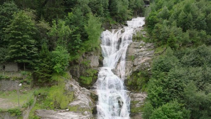 空中无人机看到的瀑布(cascata piumogna)被郁郁葱葱的绿树包围