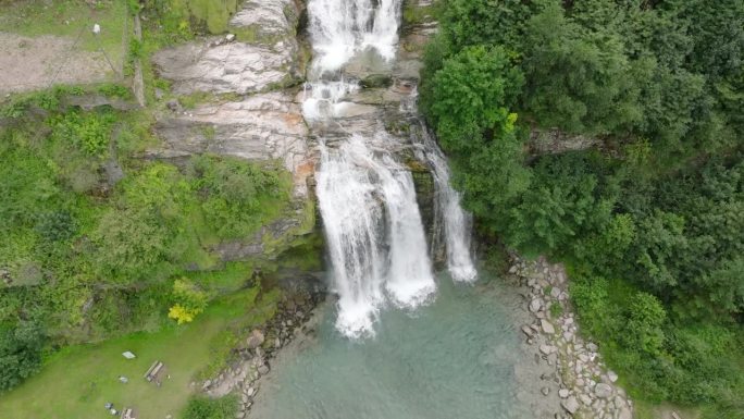 空中无人机看到的瀑布(cascata piumogna)被郁郁葱葱的绿树包围