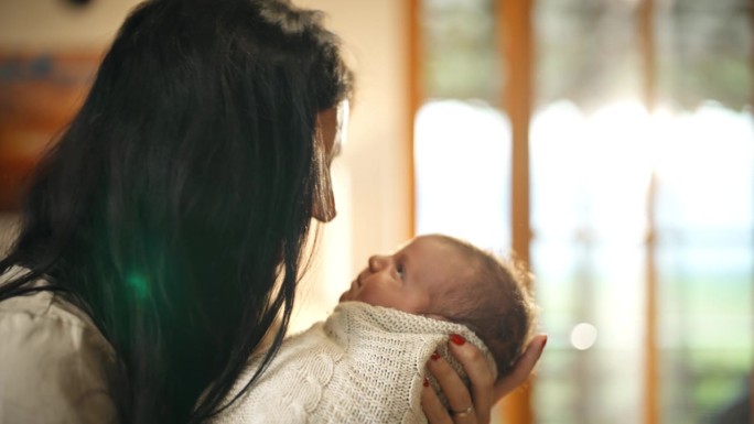 妈妈在家里抱着她刚出生的婴儿。母子的幸福时刻。