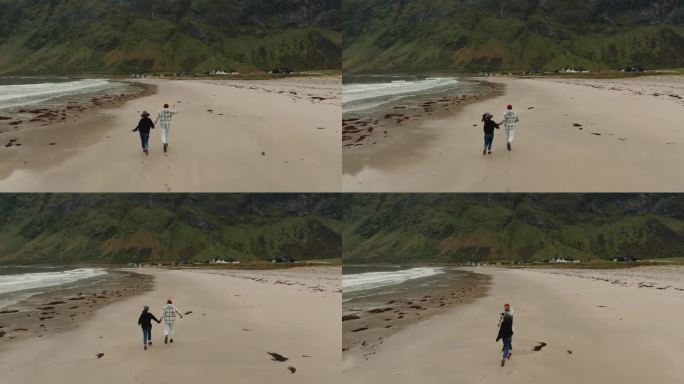 浪漫的度假。一对快乐的年轻夫妇在森加群岛的北欧海滩上跑步的俯视图
