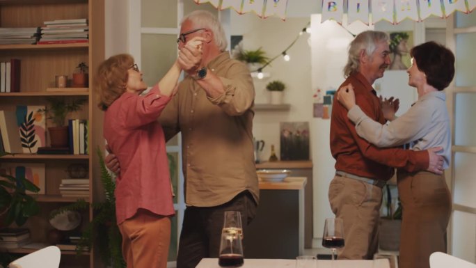 快乐的退休老人在生日庆典上跳舞